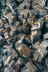 Wall Mural - Aerial view of a densely packed medieval village with stone buildings and aged rooftops, showcasing historic architecture.