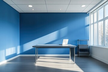 Aufkleber - A minimalist office space with a blue wall, desk, and natural light.
