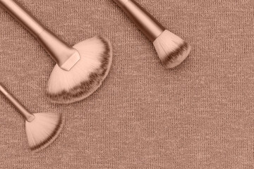 Cosmetics Professional Makeup Brush on beige knit background, flatlay