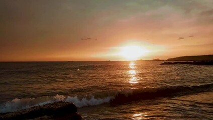 Poster - Beach on the sea with waves at sunset.