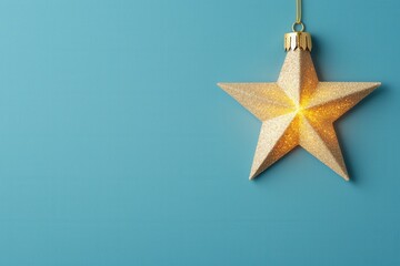 Wall Mural - a shimmering gold star ornament hangs against a blue background, adding a festive touch and warmth t