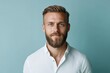 © J. Grayscale - Confident Young Man with Beard Posing Against a Soft Blue Background