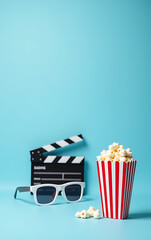 Aufkleber - A movie clapper, 3D glasses, and striped popcorn box are displayed on a light blue background for promotional use._00001_