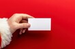 © Giorgi - Hand holding blank card on bright red festive background