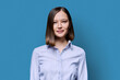 © Valerii Honcharuk - Headshot portrait of young serious woman on blue background