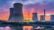 © Janos - A nuclear power plant with cooling towers under a cloudy sky during dusk.
