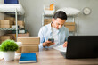© AntonioDiaz - Latin entrepreneur managing his ecommerce business and checking orders on his smartphone while working at his home office