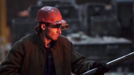 A worker wears a safety helmet and goggles for protection in an industrial setting. Stock Clip