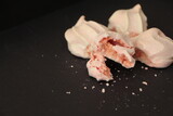 Soft pink Meringue cookies and crumbs. Crispy meringue. Meringue cookies made from egg whites and sugar. Mini pavlova or French baiser dessert. Broken meringues.