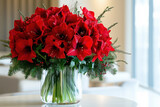 Beautiful Cbouquet of red amaryllis flowers with pine branches in a glass vase