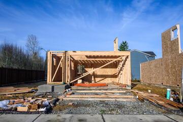 Wall Mural - New housing development with wood frame construction started on new home lot, messy job site on a sunny fall day
