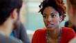 © Aditya - A young Black woman with auburn highlights in her hair listens intently during a conversation.