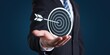 © MediaStockAI - Businessman Holding a Bullseye Target with an Arrow