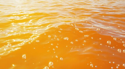 Poster - Vibrant orange water surface with bubbles reflecting sunlight creating an abstract and serene natural scene