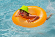 © Olena - Child boy in swimming pool with inflatable toy ring. Kids swim on summer vacation. Swim for child on float. Beach sea and water fun.