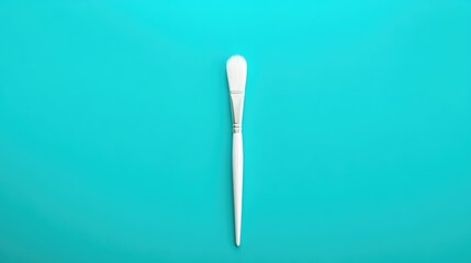 Poster - Minimalist composition of a white paint brush on a vibrant turquoise blue background showcasing creativity and artistic expression