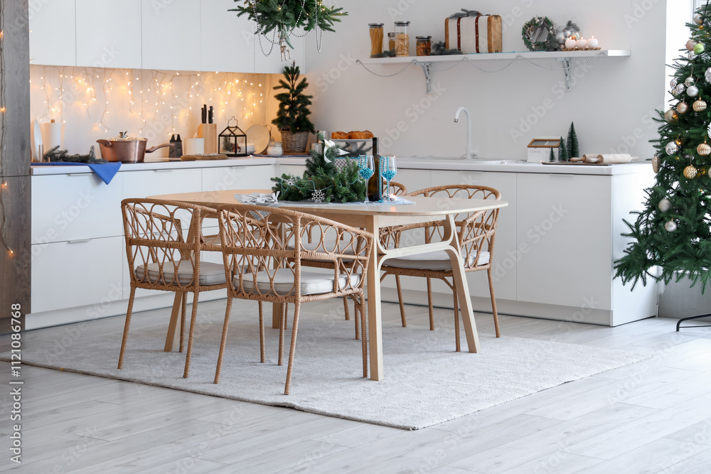 Interior of modern kitchen with festive table setting, glowing lights and Christmas decorations