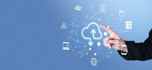 Fototapete - Hand pointing at glowing cloud icon surrounded by technology symbols on a blue background.