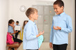 © Pixel-Shot - Little boys talking at school hall
