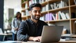 © diowcnx - [Young man working quietly] Productive study session: Casual office worker seated at wooden desk with laptop and bookshelf background.