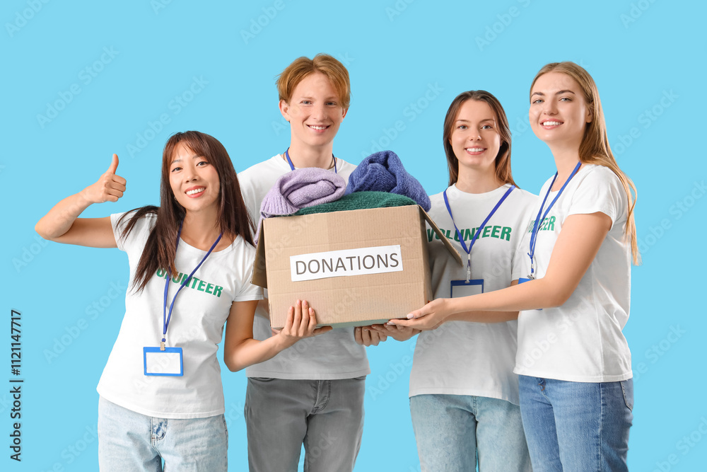 Group of volunteers with donations on blue background