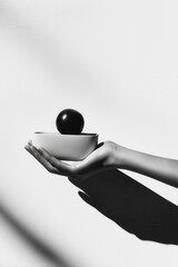 Poster - Minimalistic Black and White Image of Floating Bowl and Sphere on Hand