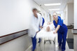 © peopleimages.com - Doctor, team and rushing with patient in hospital for healthcare emergency or life saving surgery. Motion blur, medical group and running with stretcher for intensive care, urgent ER help and support