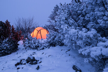 illuminated tent in a white winter landscape at night