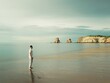 © macizogalaico - A lonely man on the shore of the beach looks out over the cliff with the silky water and sunny sky in the background.