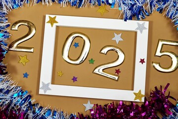 Wall Mural - golden numbers 2025 two thousand twenty five new year with colorful tinsels and stars on brown background