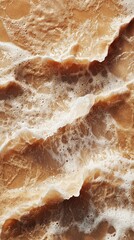 Poster - Smooth brown mocha sand flows across the shore, kissed by foamy waves. The tranquil atmosphere evokes a peaceful connection with nature on a sunny afternoon, inviting relaxation and reflection