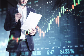 Wall Mural - Businessman analyzing financial data on paper with stock market charts in the background.