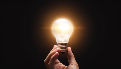 Poster - A hand holding a glowing light bulb in darkness