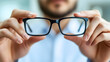 © olenap - Doctors hands holds glasses. Stylish eyewear with reflection in lenses of glasses. symbolizing vision correction and modern style. Optical store or vision correction concept.