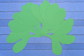 Wall Mural - layered, die-cut paper leaves on blue paper with stripes