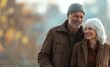 © Tondone - Elderly couple enjoying a leisurely walk in a park on a crisp autumn day, showcasing love, happiness, and companionship in their golden years.