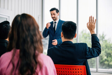 Wall Mural - Group of business leaders presents their reviews in a meeting room, with a diverse audience of colleagues sitting, listening, and engaging. reflects essence of teamwork and productive discussions.