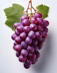 Wall Mural - A bunch of ripe red grapes with vibrant color and fresh green leaves.