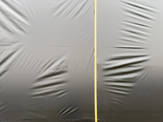 Wall Mural - A black plastic sheet with a yellow line running through it