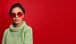 © Niser - Generated imageStylish deer wearing red sunglasses and a cozy sweater against a bright red background, showcasing