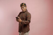 © Reezky - Surprised young Asian man in a lurik and blangkon looking at his smartphone.