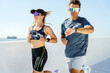 © muse studio - Fitness enthusiasts run along a coastal pathway with city views during a sunny morning