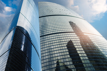 Poster - A tall building with a large glass window. The building is in the city. The sky is blue