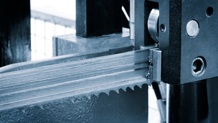 Aufkleber - A machine with a blade that is cutting a piece of metal. The blade is made of steel
