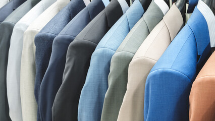 Poster - A row of suits hanging on a rack. The suits are in different colors and styles