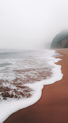Aufkleber - Soft waves caress the brown sand while fog blankets the beach, creating a serene and tranquil atmosphere by the sea