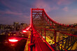© Austockphoto - Red illuminated lights along the structure of the Story Bridge at dusk.