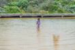© Austockphoto - 3 year old fully clothed in the water