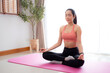 © N_studio - Young asian woman meditation sitting on mat in serene and tranquility with yoga posture lotus in living room at home, woman practice yoga with breathing balance for mindfulness, sport for health.