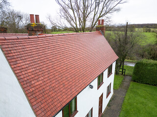 Brand new roof and tiles seen on an old English farmhouse in the UK. The original roof of the Grade 2 listed house was beyond repair.